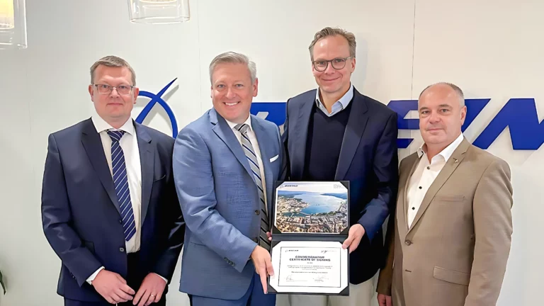 From left to right, Kim Lantz (Head of Flight Planning Solutions at ForeFlight), Kevin Sutterfield (Chief Revenue Officer of ForeFlight), Andreas Bierwirth (CEO of AvconJet), and Christian Hrauda (Accountable Manager of AvconJet) stand together holding a commemorative certificate of joining. The certificate, featuring a scenic aerial photograph, signifies a significant partnership. The backdrop displays the ForeFlight logo.