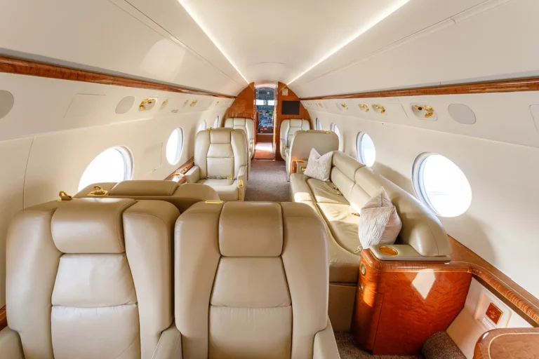 Spacious and elegant interior of a business jet, featuring comfortable leather seats and ample lighting, showcasing a tailored flight experience.
